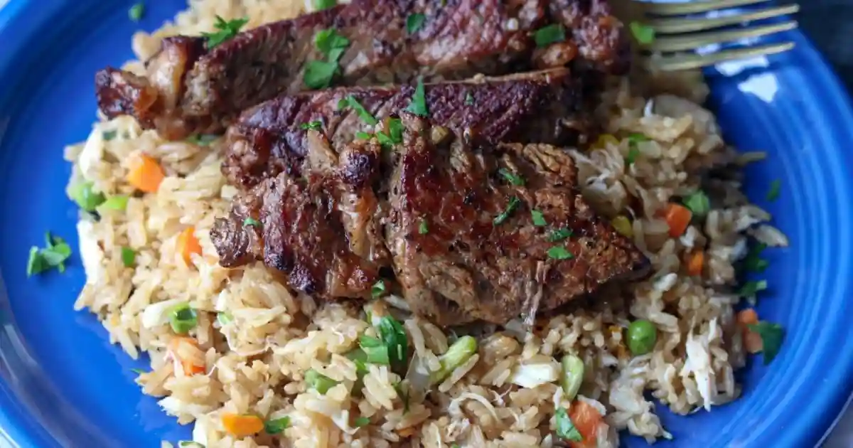A sizzling steak and rice served over fluffy rice with fresh herbs.